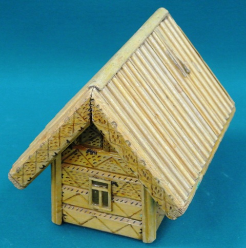 Деревянный домик с резьбой на фасаде